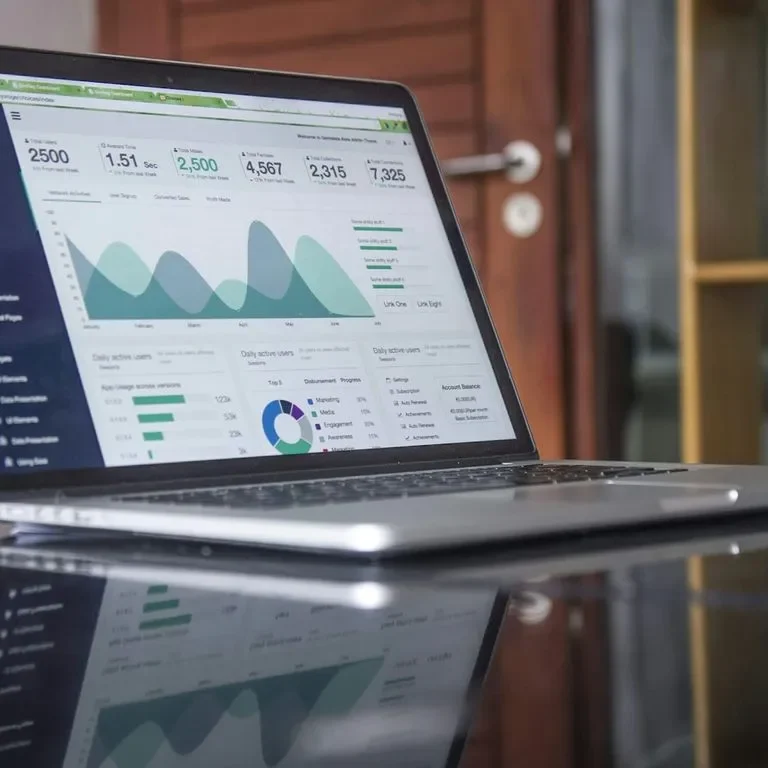 Laptop on a desk displaying financial data and graphs.